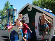 Children playing on the modern playhouse at Martha’s Park during the ribbon cutting