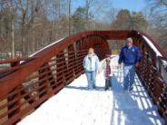 Family on pedestrian bridge in snow
