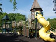 Yellow tube slide on play structure