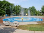 Splash pad with play structure in background