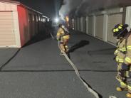 Firefighters responding to a fire using a hose