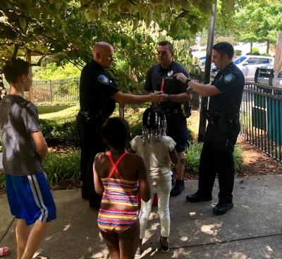 This is an image of public safety officers handing out ice pops to the community